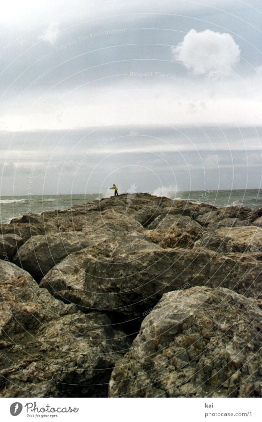 lonely angler Angler Ocean France Loneliness Gale Nature Far-off places Wanderlust Cervice Rocky coastline White crest Portrait format Stone block