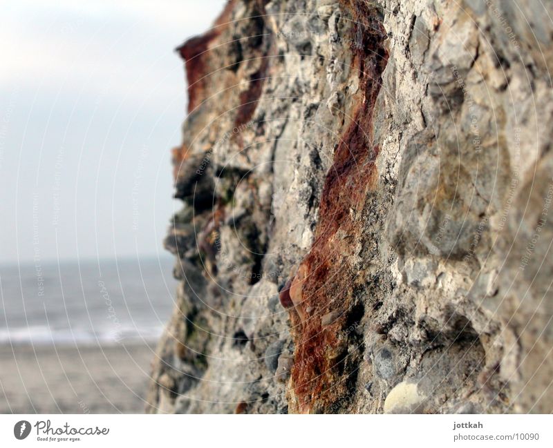 Passing the bunker Beach Ocean Sand Water Stone Old Broken Crumbled Wall (building) Dugout Structures and shapes Material Hard Rust Colour photo Exterior shot