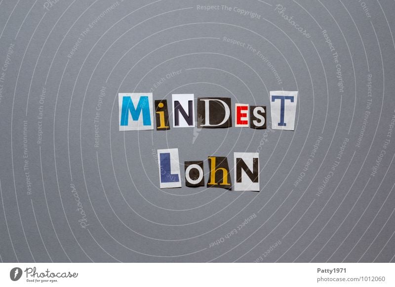 Minimum wage. Letters cut out of newspaper on a neutral, grey background. Unemployment Paying Income Sign Characters Typography Safety Solidarity Fairness