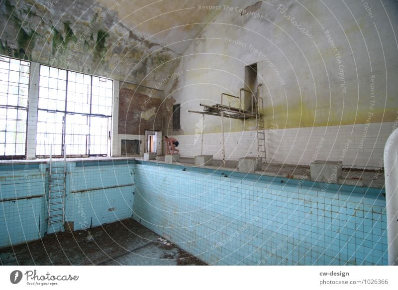 Young man at the starting jump in front of an empty swimming pool Indoor swimming pool younger Man jump to start Swimming pool Colour photo Interior shot