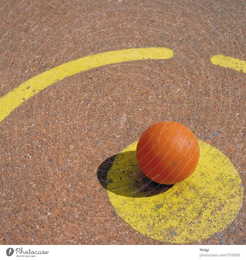 orange minigolf ball is located at the tee-off point on a minigolf course Round Mini golf Tee off Beat Playing Sporting event Yellow Red Concrete Painted Lose