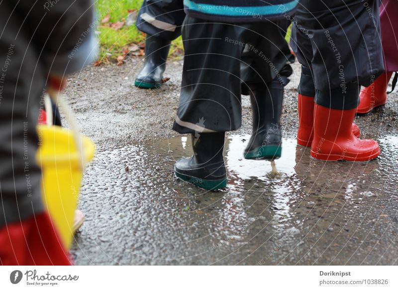 Fun in the rain Joy Playing Kindergarten Human being Toddler Infancy Life Legs Group of children 1 - 3 years Water Autumn Bad weather Village Rain suit