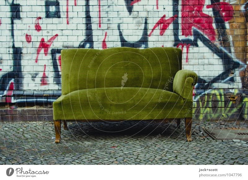 Incomplete sofa is on the sidewalk Sofa Subculture Street art Kreuzberg Wall (barrier) Sidewalk Brick Graffiti Arrow Broken Retro Green Recklessness