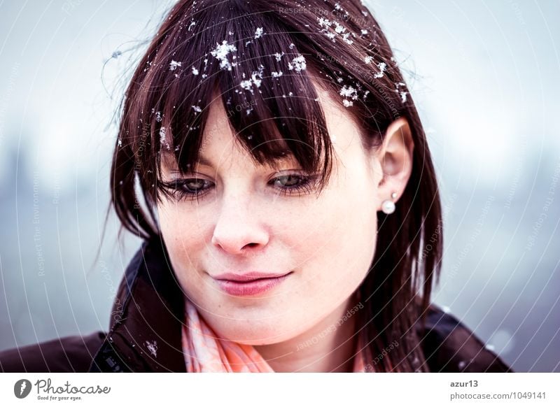 Young woman with winter depression. The cold winter makes the teenager fall into depression. The gaze is lowered down from sorrow or burnout. On the head are fine flakes of snow.