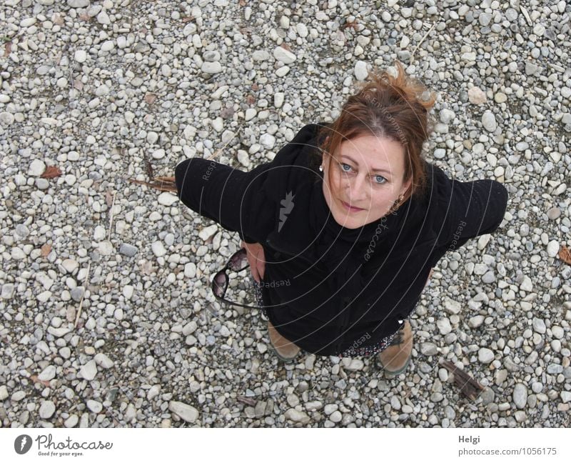 Woman with brunette hair pinned up looks friendly upwards into the camera Human being Feminine Adults 1 30 - 45 years Spring Lakeside Jacket Hiking boots