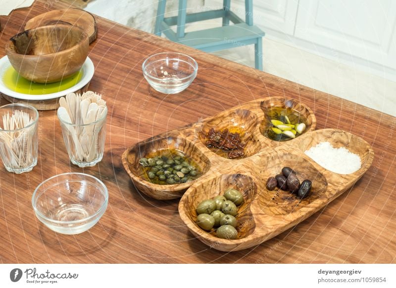 Olives in a wooden bowl for tasting. Vegetable Fruit Eating Vegetarian diet Bowl Table Restaurant Nature Leaf Fresh Green Black Ingredients Rustic Italian Greek