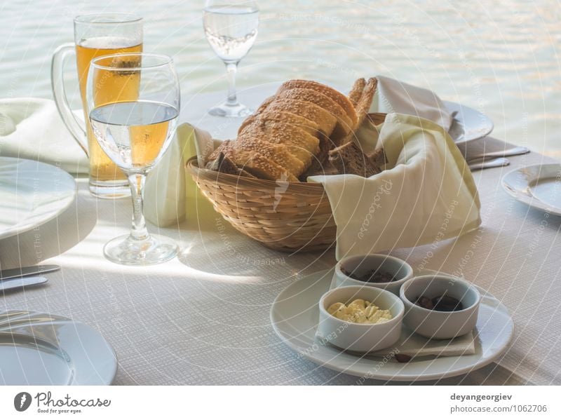 Close up table in greek restaurant. Olives and bread Cheese Bread Breakfast Dinner Vegetarian diet Plate Fork Table Restaurant Delicious Green Black White Greek