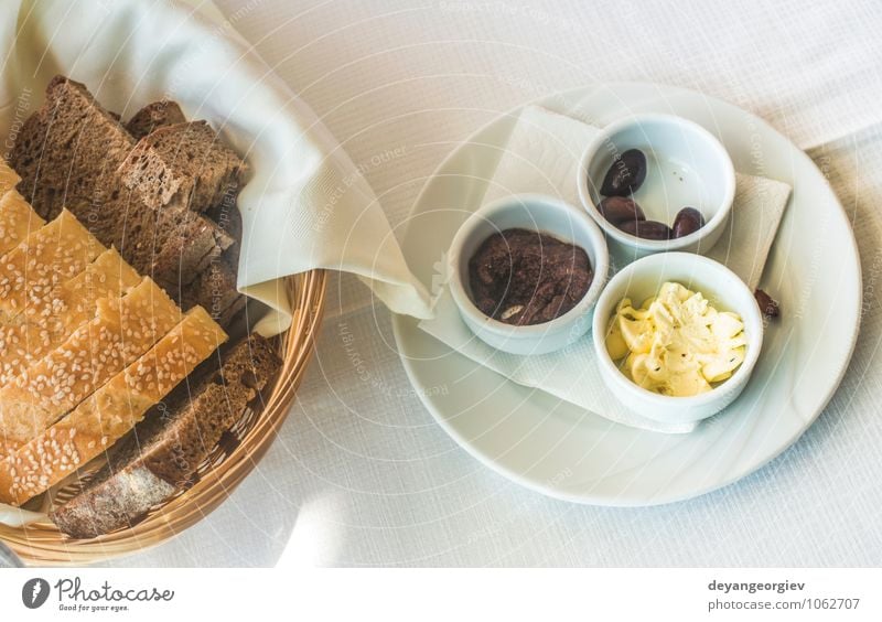 Close up table in greek restaurant. Olives and bread Cheese Bread Breakfast Dinner Vegetarian diet Plate Fork Table Restaurant Delicious Green Black White Greek