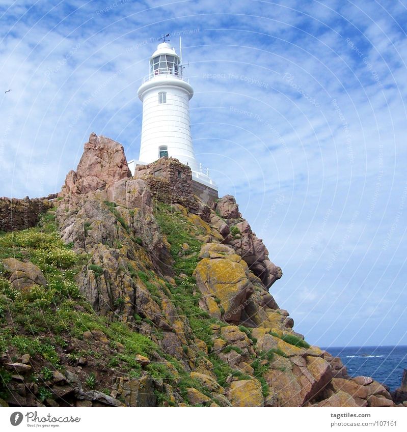 Rock in the surf Cliff Lighthouse Orientation White Green Ocean Unwavering Landmark Monument Concentrate Safety Blue Stone daytime steady stability Road marking