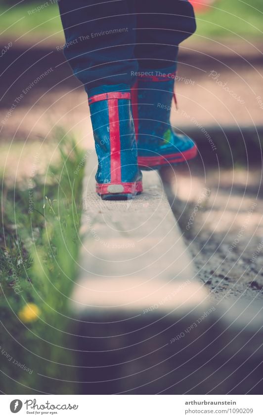 Child in colourful rubber boots balanced on the edge of a sandbox Joy Happy Playing Children's game Summer Sun Garden Human being Masculine Infancy Feet 1