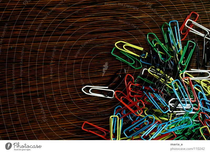 chaos of clamps Paper clip Chaos Muddled Multicoloured Wood Yellow White Reddish black Green Flexible Wire Attachment paperclip chaos Wood grain