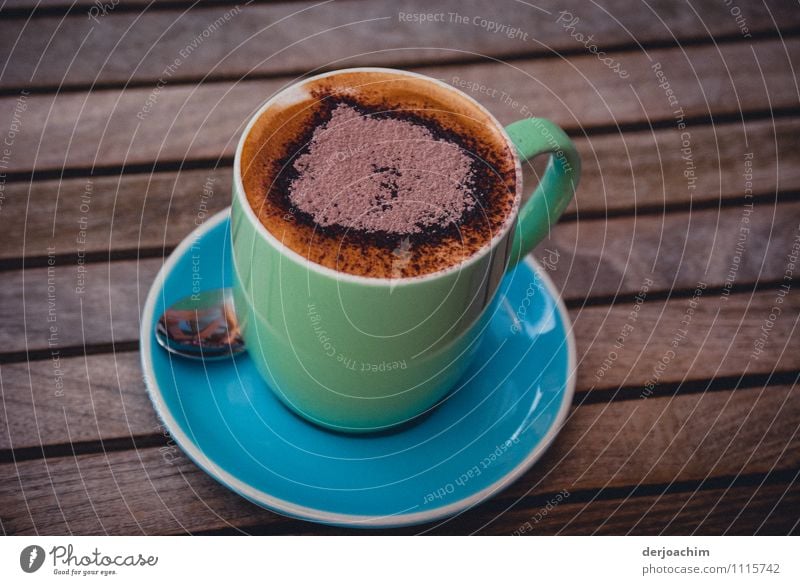 A cup of cappuccino with a heart. Cup stands on a wooden table with a spoon and saucer. Chocolate To have a coffee Hot drink Cappuccino Spoon Joy Healthy