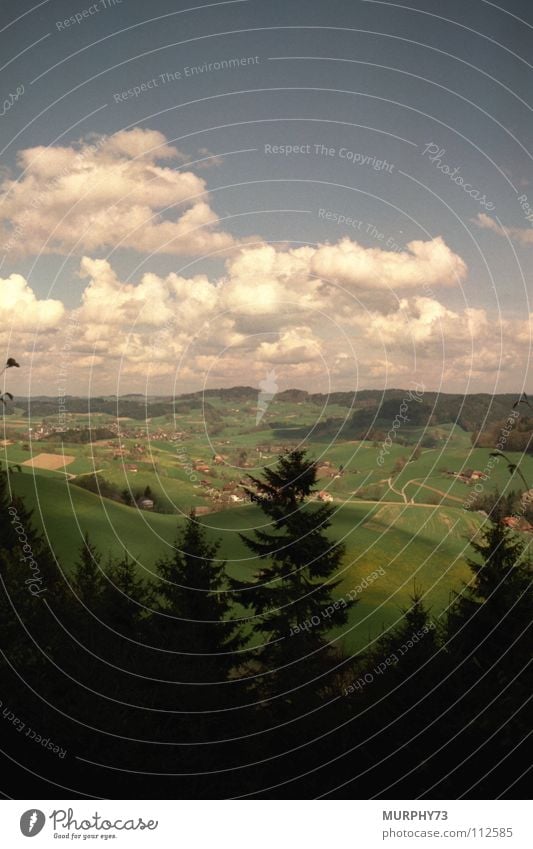 Summer day in Swiss Oberaargau Clouds Forest Hill White Green Black Sky Switzerland in the country farming villages Shadow Blue