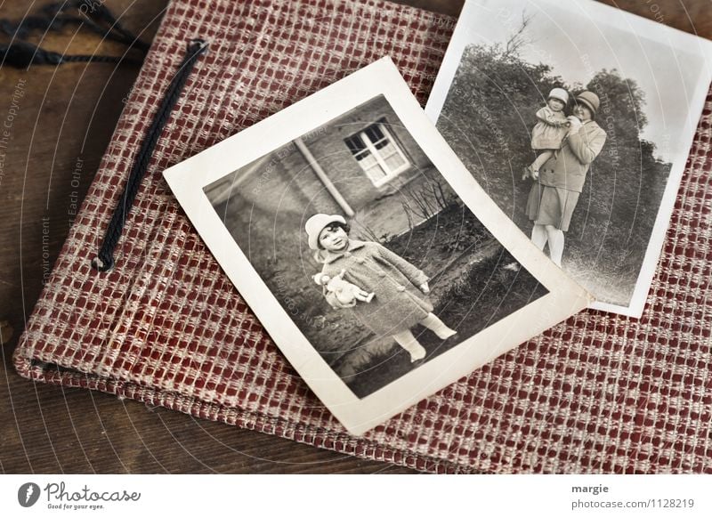 Photo album with old photos, child with doll, mother with child on her arm, both wearing hats Human being Feminine Child Toddler Girl Young woman