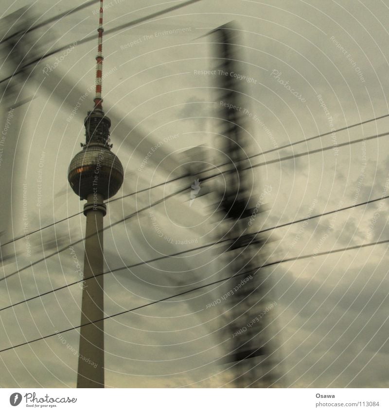 Tower passing by Alexanderplatz Concrete Commuter trains Window Rain Clouds Cloud cover Gray Bad weather Landmark Monument Berlin TV Tower Window pane Glass