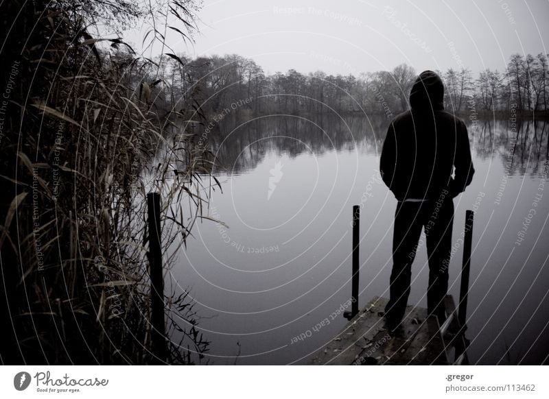 Monk by the sea Autumn Winter November Gray Bland Damp Wet Bad weather Cold Vantage point Looking Calm To be silent Listening Lake Pond Footbridge Stand Dreary