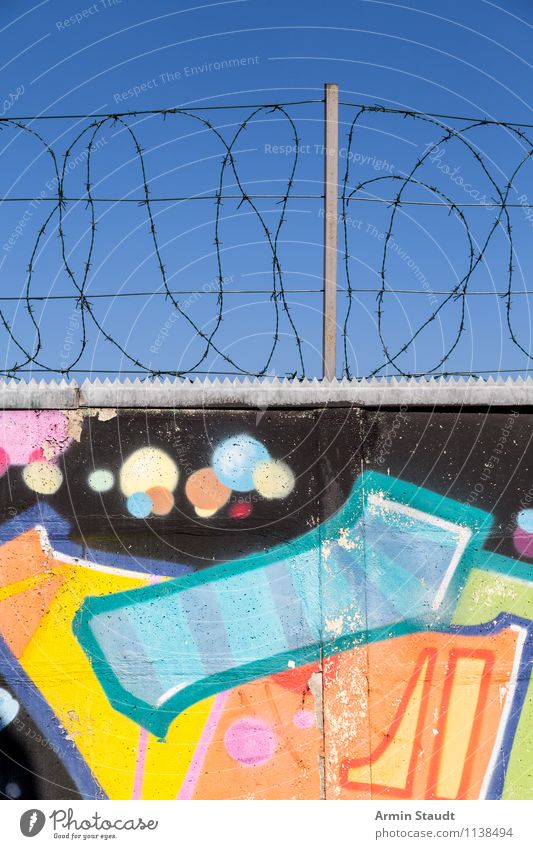 Pretty wall with barbed wire Graffiti Cloudless sky Summer Wall (barrier) Wall (building) Concrete Concrete wall The Wall Barbed wire Stone Metal Authentic