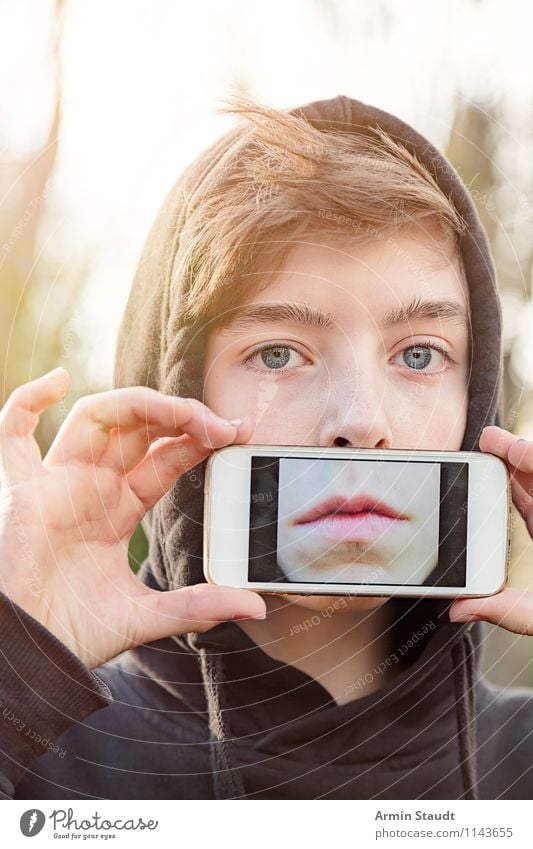 Youngsters hold a mobile phone in front of their mouth with a photo of their mouth on the display Lifestyle Style Design Telecommunications PDA Technology