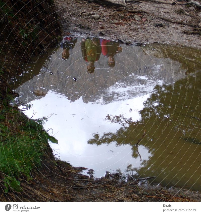 Mirror, mirror ... Puddle Grass Gray Mud Dolomites Peak Child Mirror image Clouds Dark Planning Coniferous trees Italy Water Mountain Rock Sky Val Gardena Snow