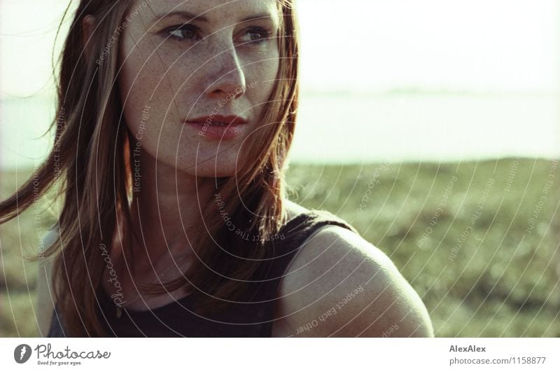 young slim woman with freckles and red hair stands in sunlight by river Trip Far-off places Freedom Summer Young woman Youth (Young adults) Face Freckles