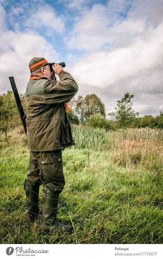 Hunter looking in binculars Relaxation Leisure and hobbies Hunting Sports Human being Man Adults Nature Landscape Autumn Jacket Hat Dog Binoculars Observe Stand