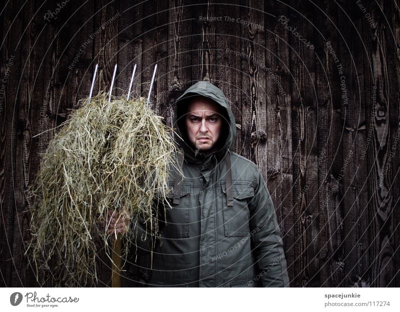 farmer seeks woman Man Portrait photograph Freak Wall (building) Wood Winter Cold Work and employment Cleaning Evil Ferocious Straw Manure heap Pitchfork Farmer