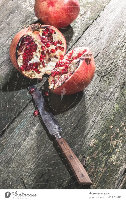 Pomegranate on vintage wooden table Fruit Dessert Eating Vegetarian diet Diet Juice Table Old Dark Fresh Retro Juicy Red Colour knife food ripe sweet Organic