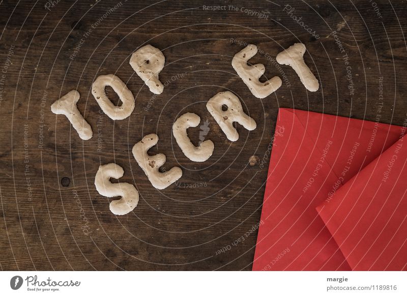 The letters TOP SECRET with a red envelope on a rustic wooden table Education Examinations and Tests Work and employment Office work Economy Industry Trade