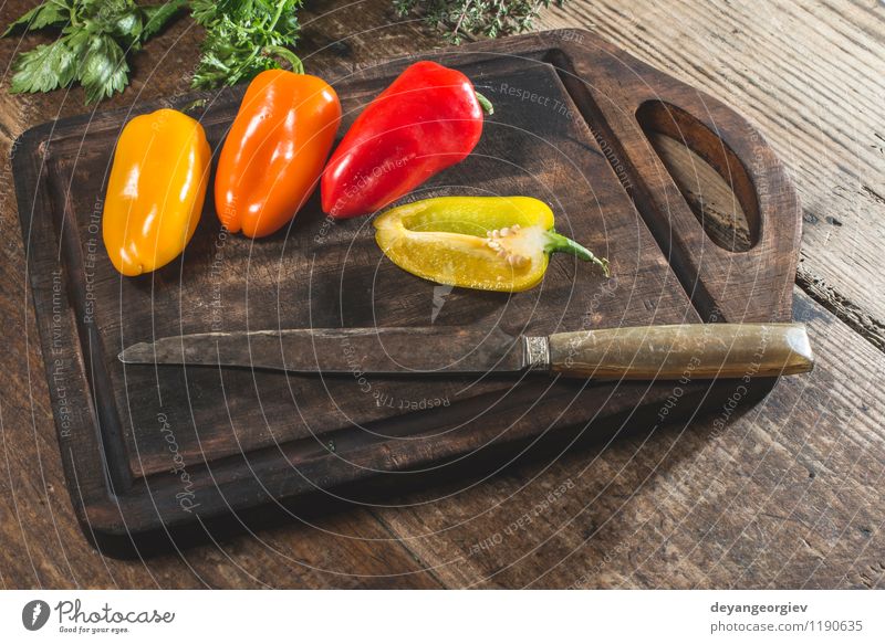 Multicolored peppers on wood Vegetable Fruit Nutrition Eating Vegetarian diet Fresh Natural Juicy Yellow Green Red White Colour food knife background bell