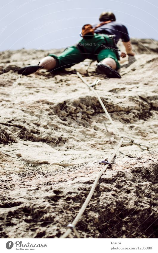 Young man climbing up a mountain on a rope 1 Human being Athletic Climbing Strong Weight training Force Sportsperson Climbing rope Climbing shoes