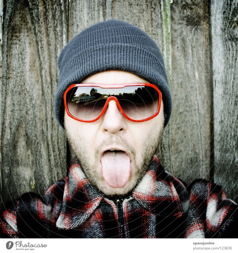 rock it! Man Portrait photograph Freak Scare Wall (building) Wood Eyeglasses Sunglasses Cap Winter Cold Freeze The eighties Easygoing Whimsical Humor Joy Tongue