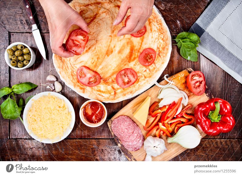 Making homemade pizza Food Sausage Cheese Vegetable Dinner Fast food Bowl Knives Table Hand Leaf Fresh Basil board cuisine dough Garlic Grating grated Home