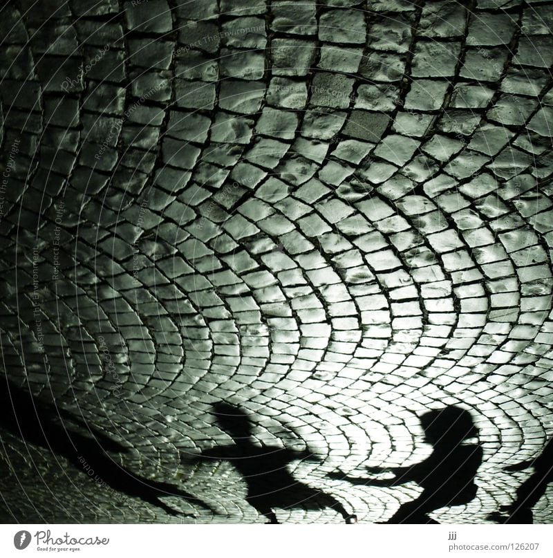 street scene Cobblestones Light Silhouette Playing Black Dark Cone of light Cinema Group Fear Panic Shadow Arch Stone Street Human being Arm Catch Dance Hat