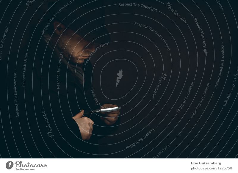 Man tests his razor in the dark Style Personal hygiene Human being Masculine Face Hand Fingers 1 30 - 45 years Adults Coat Scarf Hat Braids Facial hair