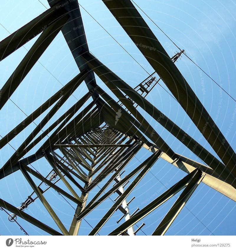 Power pole from the inside from the frog's perspective in front of a blue sky Electricity pylon Wire Clouds White Gray Large Might Geometry Steel Towering