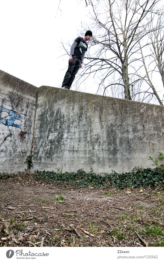 slanting position Tumble down Dangerous To fall Rubber Stand Beginning White Jeans Fire hydrant Red Adjustment Wall (building) Building Wall (barrier) Cap