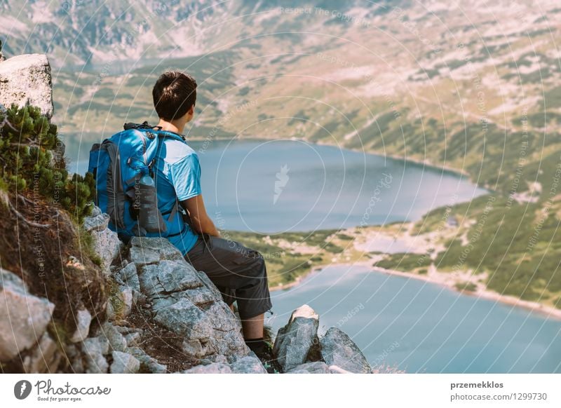 Teenager resting on rock and looking at the mountains Lifestyle Beautiful Vacation & Travel Trip Adventure Freedom Summer Mountain Hiking Boy (child) Young man