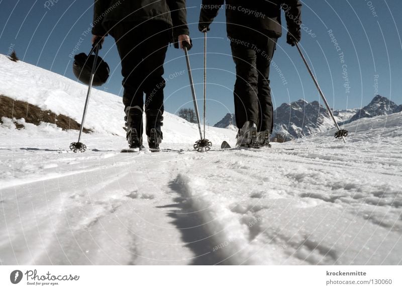 black in white Winter Skiing Skier White Skis 2 Winter sports Winter vacation Cold Ski pole Helmet Mountain range Worm's-eye view Black Snowsuit Effort