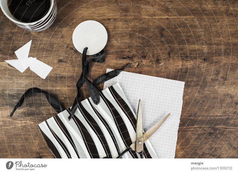 gift wrap with scissors, a black and white bag and a cup of coffee Beverage Coffee Cup Leisure and hobbies Handicraft Gift wrapping Desk Workplace Zebra