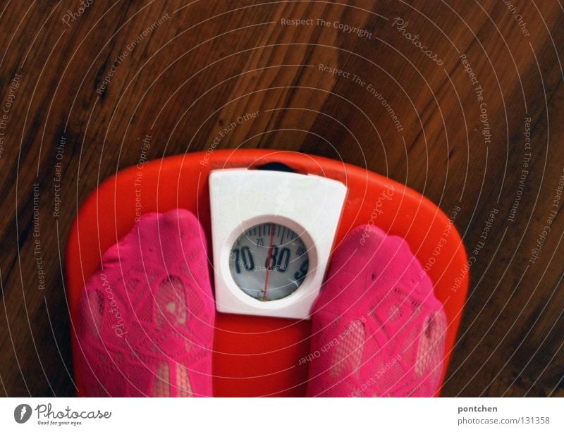 Woman standing on orange vintage scale, which reads 78kg. Overweight, diet. Diet pretty Healthy Healthy Eating Scale Adults Feet Stockings Sustainability Round