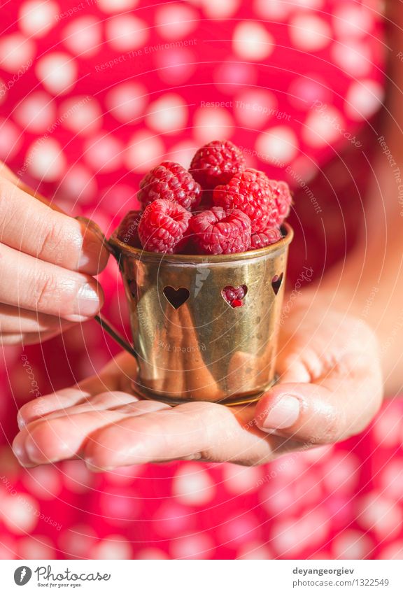 Woman in red dress holding a cup of raspberries Fruit Vegetarian diet Lifestyle Summer Garden Girl Adults Hand Heart Love Fresh Natural Green Red Romance