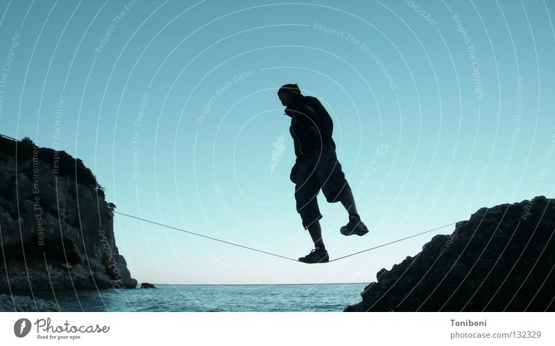 Slackline III Contentment Ocean Man Acrobat Coast Diagonal Single-minded Sardinia Italy Silhouette Evening sun Colossus Cool (slang) Easygoing Extreme sports