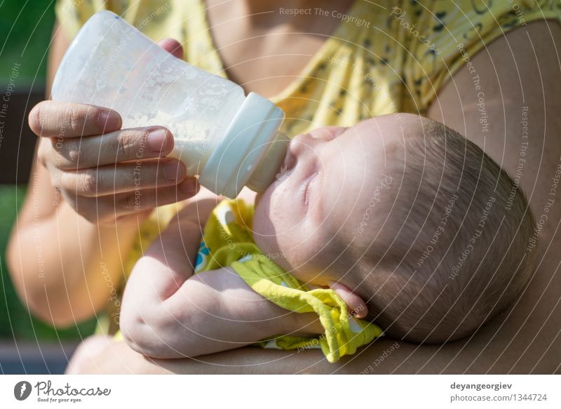 Baby sucks on a bottle. Eating Drinking Bottle Happy Face Girl Mother Adults Plastic Feeding Small White milk food kid care Newborn Dairy Suck young drink one