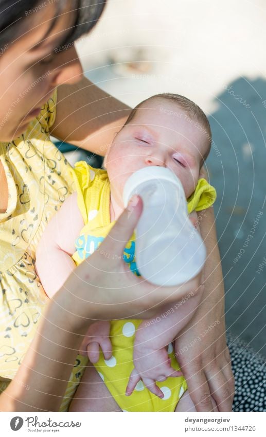 Baby sucks on a bottle. Eating Drinking Bottle Happy Face Girl Mother Adults Plastic Feeding Small White milk food kid care Newborn Dairy Suck young drink one