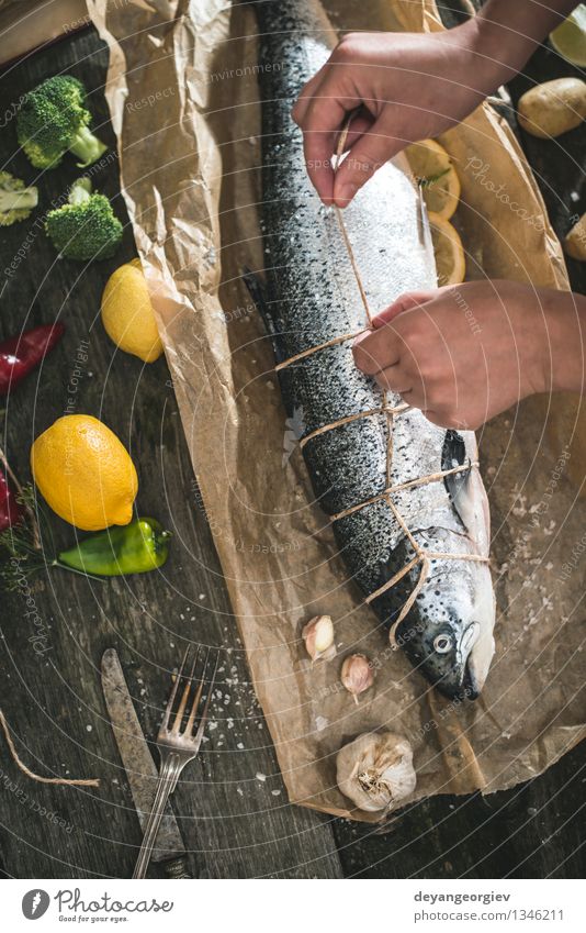 Tying a rope on fish for grilling Seafood Vegetable Dinner Table Cook Rope Hand Paper Dark Fresh Delicious Black Cooking Raw Ingredients Meal Lemon Preparation