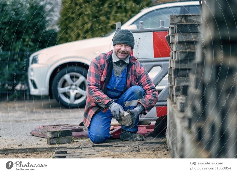 Cheerful workman in winter clothing smiling at the camera Happy Face Winter Snow Work and employment Craftsperson Man Adults Weather Street Scarf Hat Brick