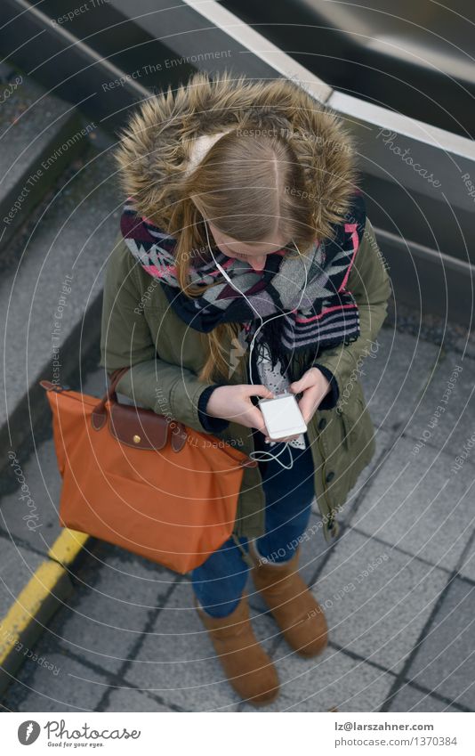 Young woman checking an sms on her mobile Reading Winter University & College student Telephone PDA Screen Technology Woman Adults 1 Human being 13 - 18 years