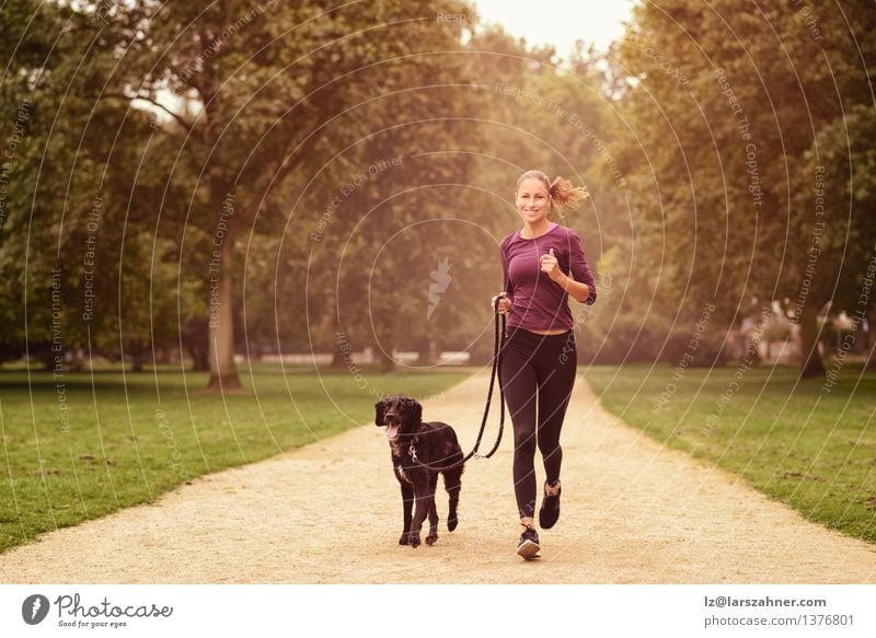 Healthy Woman Jogging in the Park with her Dog Lifestyle Relaxation Summer Sports Adults Friendship Animal Lanes & trails Pet Fitness Smiling Together Sunset