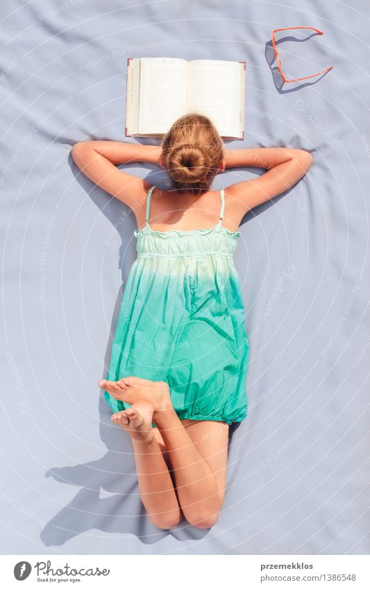 Girl lying on a blanket and reading a book on a sunny day Lifestyle Relaxation Leisure and hobbies Reading Summer Child Study Human being Youth (Young adults) 1