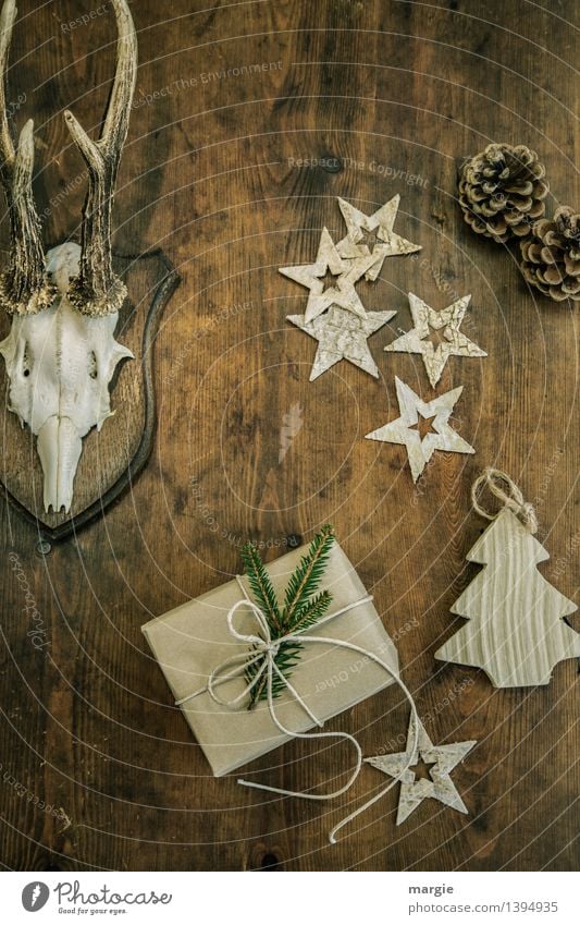 Merry Christmas! One present, five stars a Christmas tree - pendants, two pine cones and antlers hang on a wooden wall Hunting Living or residing Decoration